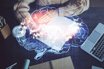Multi exposure of writing hand on background with brain hologram. Concept of learning.