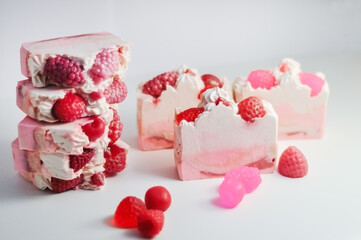 Obraz na płótnie Canvas Handmade pink soap.Cold Processed Handcrafted Soap.Home made soap look like cake, ice cream with berries,glitter on gray background with sparkles.Natural homemade cosmetics and handmade soaps concept