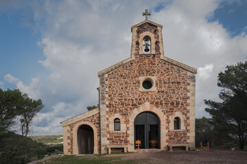 Fototapeta na wymiar mediterranean little chapel over a hill in the countryside. Menorca, Spain.