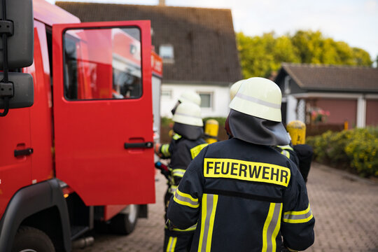 Symbolbild Feuerwehr mit Feuerwehrmann vor einem Feuerwehrauto