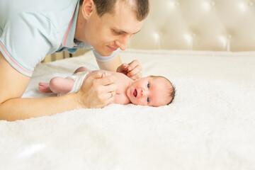 Woman and man giving a newborn baby. Mom, dad and baby. Close-up. Portrait of a young smiling family with a newborn baby in their arms. Happy family on the background.