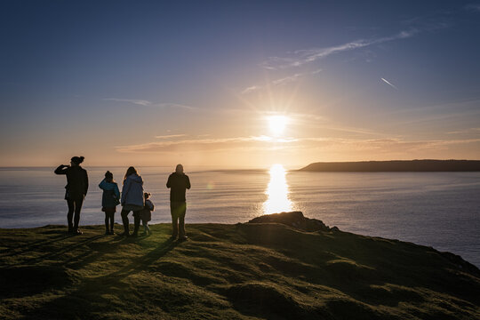 People watching sunset at Rhossili Bay, Worm's head, Gower Peninsula beach, Swansea, Wales, United Kingdom, Europe