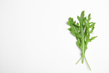 Fresh arugula on white background, flat lay. Space for text