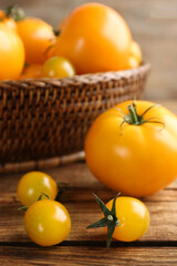 Ripe yellow tomatoes on wooden table, closeup