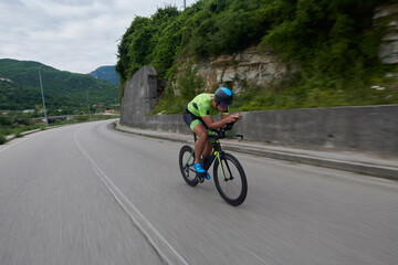 Obraz premium triathlon athlete riding a bike on morning training