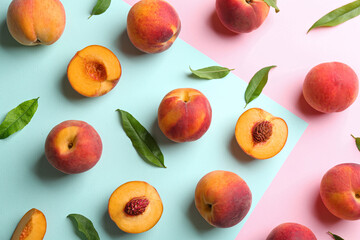 Fresh ripe peaches and green leaves on color background, flat lay
