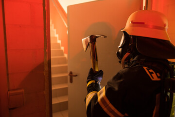 Feuerwehrfrau mit Spitzhacke während einer Übung
