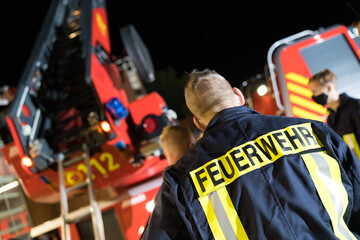Symbolbild Feuerwehrmann vor Drehleiter