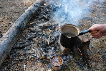 Brewing coffee on a campfire in Ukraine. Tourism concept.