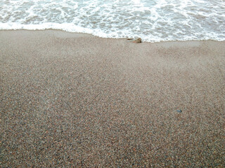 waves on the beach with black sands. 