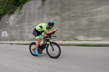Naklejka premium triathlon athlete riding a bike on morning training