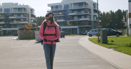 Fast food delivery courier rides electric scooter