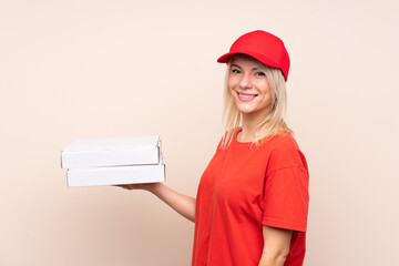 Pizza delivery Russian woman holding a pizza over isolated wall smiling a lot