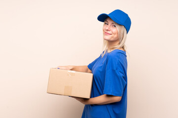 Young delivery woman over isolated background laughing