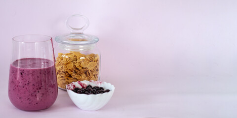 smoothies of berries and cornflakes on a pink background