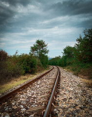 Obraz premium Dramatic scene of Eastern Europe railroad tracks with cloudy sky over it 