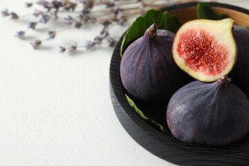 Whole and cut tasty fresh figs on white table, closeup. Space for text