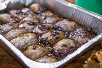 Baked stuffed Onions lays in a metal container