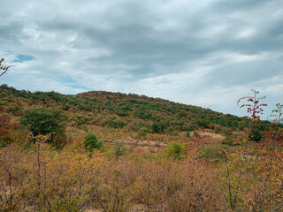 Autumn colors and cloudy sky over hills in Rhodope Mountains, Bulgaria