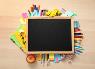 Blackboard, stationery, apple and flowers on wooden table, flat lay with space for text. Teacher's...