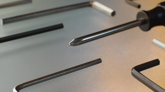 Extreme close up screwdrivers and hex keys on a glass table. Hex and phillips screwdrivers. Camera slowly moving on slider, dolly shot, macro plan.