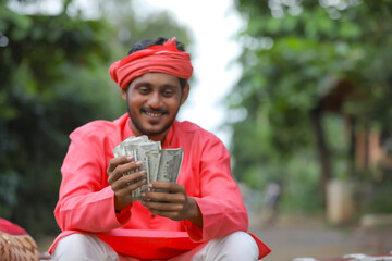 Young indian farmer counting money