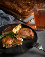 A portion of homemade fish pie on the table and a glass of tea close up in a rustic style