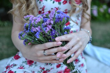Fototapeta premium Very nice young woman holding beautiful bouque. Cropped photo, bouquet close up