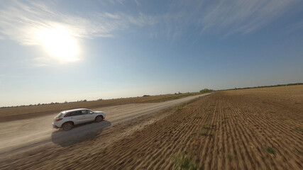 Car riding against sun in field