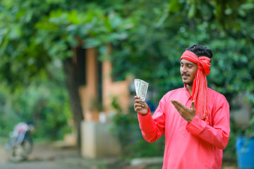 young indian farmer posing with money