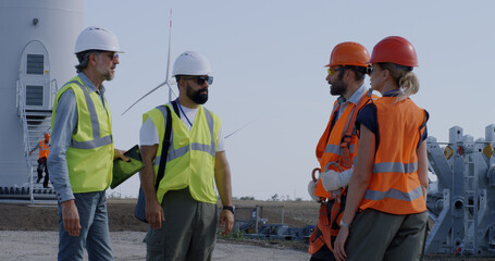 Engineers inspecting construction site near windmill