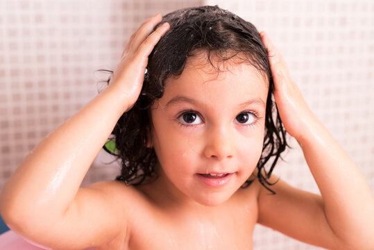 Little three years old girl washing her head