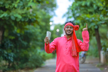young indian farmer posing with money