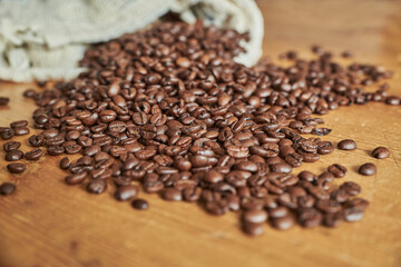 Closeup of espresso beans on a wooden vintage table. Coffee beans and coffee beans bag on a wooden table.