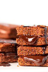 Tasty homemade chocolate cake with chocolate filling on a white background close-up. Free space for text. Stack of chocolate brownies. Sweet food, homemade cakes. Copy space.