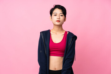 Young sport Asian woman over isolated pink background stretching arm