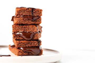 Tasty homemade chocolate cake with chocolate filling on a white background close-up. Free space for text. Stack of chocolate brownies. Sweet food, homemade cakes. Copy space.