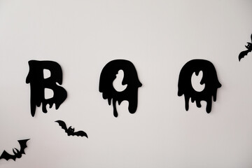 Obraz premium Paper bats and word BOO on white wall. Halloween decor