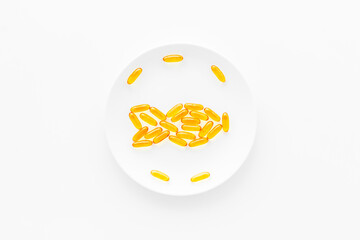 Omega fish oil supplement on plate from above