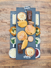 A beautiful gourmet selection of english afternoon tea cakes and scones served with organic...