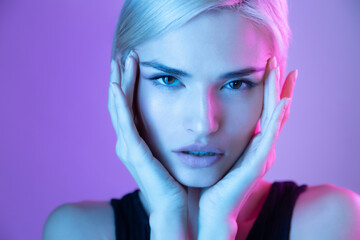 Fashion beauty portrait of beautiful girl with natural makeup and glowing facial skin in neon light 