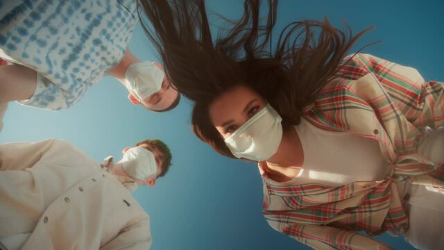 Students Wearing Masks, Teenagers Standing In Circle, Young People, Man And Woman, Medical Protection Safety Coronavirus Covid 19 Masks, Low Angle. Generation Z Millennials Have Fun On Party 