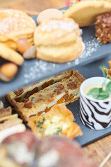 A beautiful gourmet selection of english afternoon tea cakes and scones served with organic cupcakes, tea and coffee, strawberry jam and clotted cream. traditional british food.