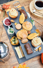 A beautiful gourmet selection of english afternoon tea cakes and scones served with organic...