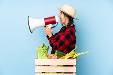 Young farmer Woman holding fresh vegetables in a wooden basket shouting through a megaphone