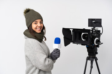 Reporter woman holding a microphone and reporting news over isolated white background with arms...