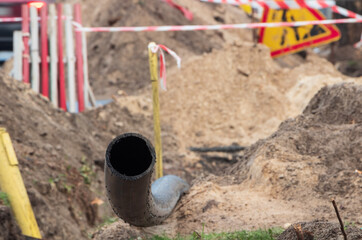 Black plastic pipe for underground water supply. PVC pipe. Sewer system repair. Close up.