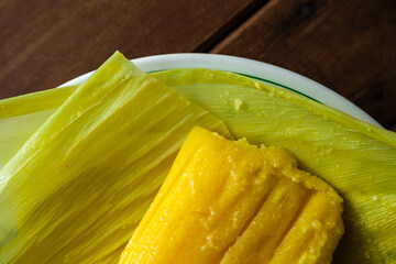 Pamonha sobre folhas de milho verde dentro do prato. Comida típica de Goiás.