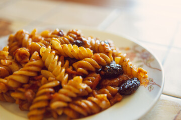 Plate pasta with prunes, beef and tomato ketchup.