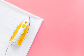 Household laundry ironing concept. Iron with clothes top view
